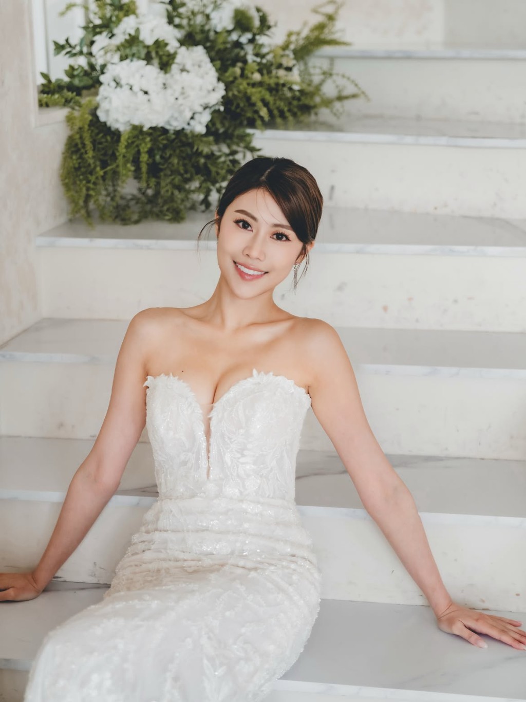 她坐在白色階梯前，氣質宛如女神。