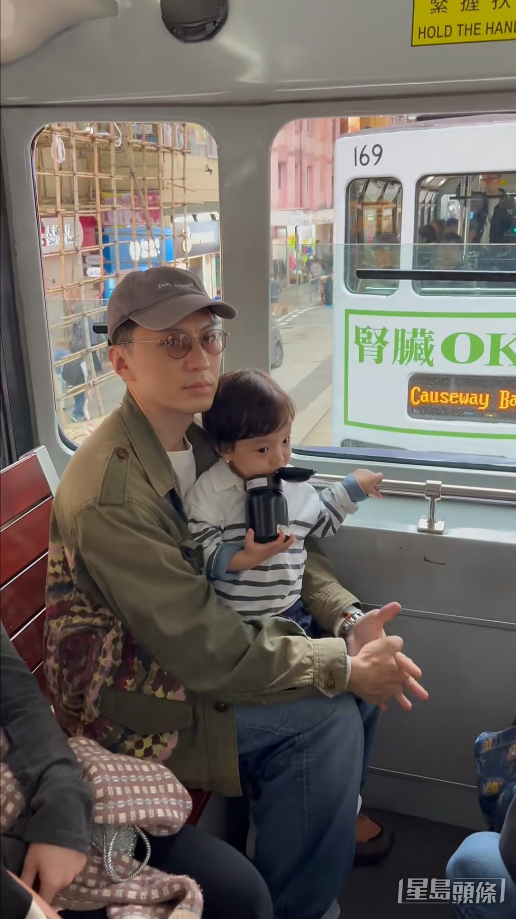 「家庭男」袁偉豪抱著兒子乘坐電車。