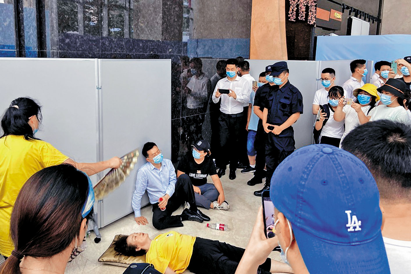 恒大爆雷後,總經理杜亮被投資者圍堵謾罵,累得癱坐在地。路透社
