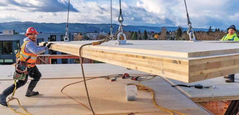 圖為起重機運送大塊重型木到建屋工地。WoodWorks