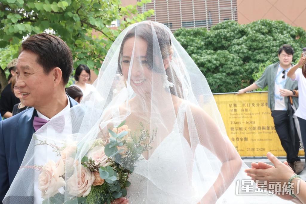 吳嘉儀由爸爸陪同進入婚禮場地。
