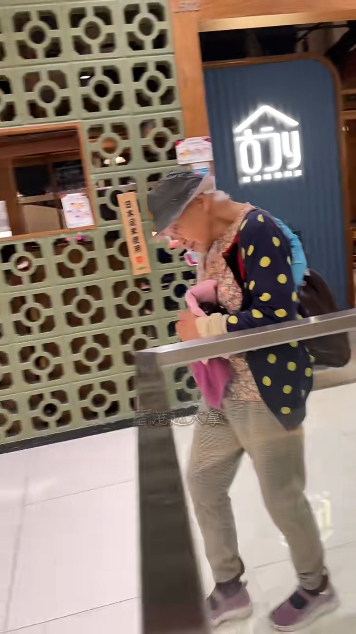 周聰玲頭戴黑色漁夫帽,身穿碎花上衣及黃色波點外套,在商場內走向餐廳。