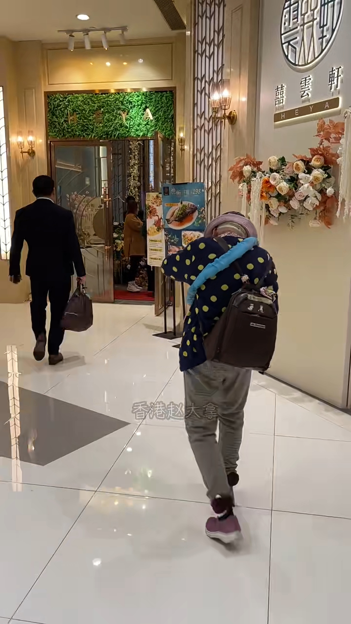 周聰玲步行頗為費力,面部朝向地面,移動緩慢。