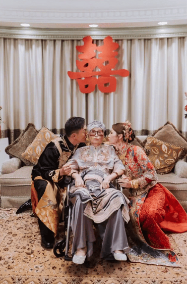 婚禮上,莊思明與楊明左右親吻坐在輪椅上的母親。