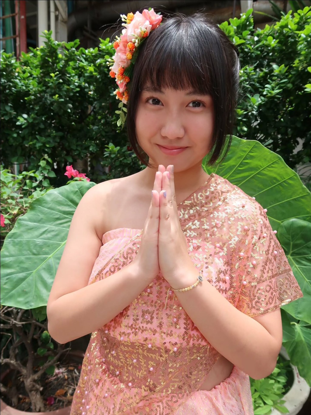 楊鎧凝換上粉金色的泰國傳統服飾,雙手合十體驗文化。