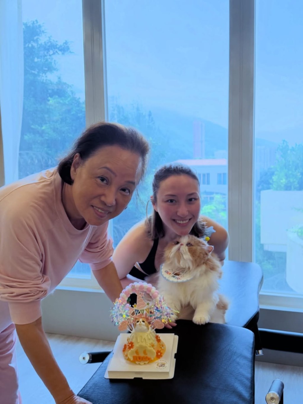 何超雲抱著寵物貓與媽媽陳婉珍合影。