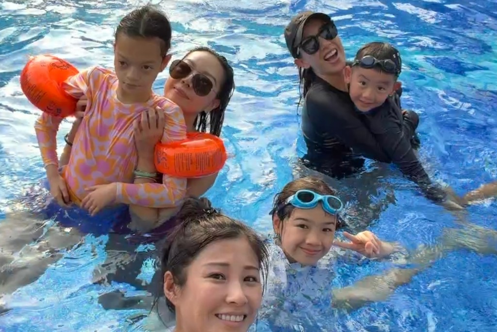 鍾麗淇抱着行動不便的長女,在泳池嬉水消暑。