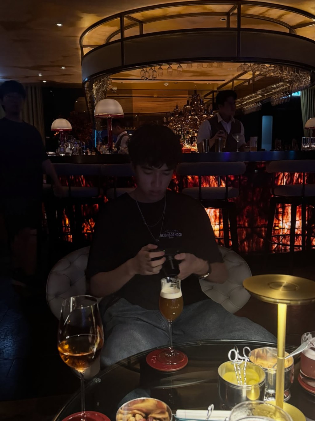 在優雅的酒吧環境中,李立仁正專心研究手上的相機。