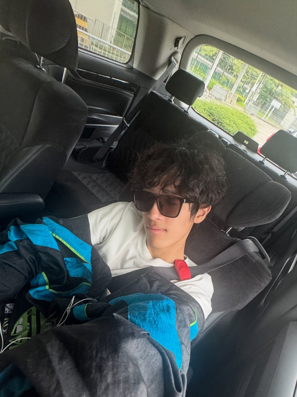 一天行程結束後,李立仁戴上墨鏡在車廂後座休息。