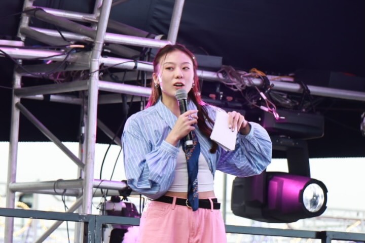 袁絲珩手持麥克風與講稿擔任大會司儀,台風淡定大方。