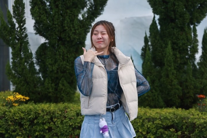 袁絲珩穿上羽絨背心配襯牛仔裙,眨眼比手勢,散發鄰家女孩魅力。