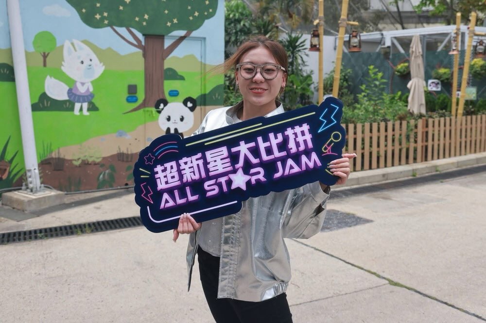 袁絲珩手持「超新星大比拼」活動燈牌,露出甜美親切的笑容。