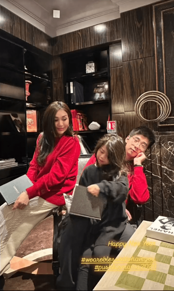 何超盈女兒坐在爸爸腿上。