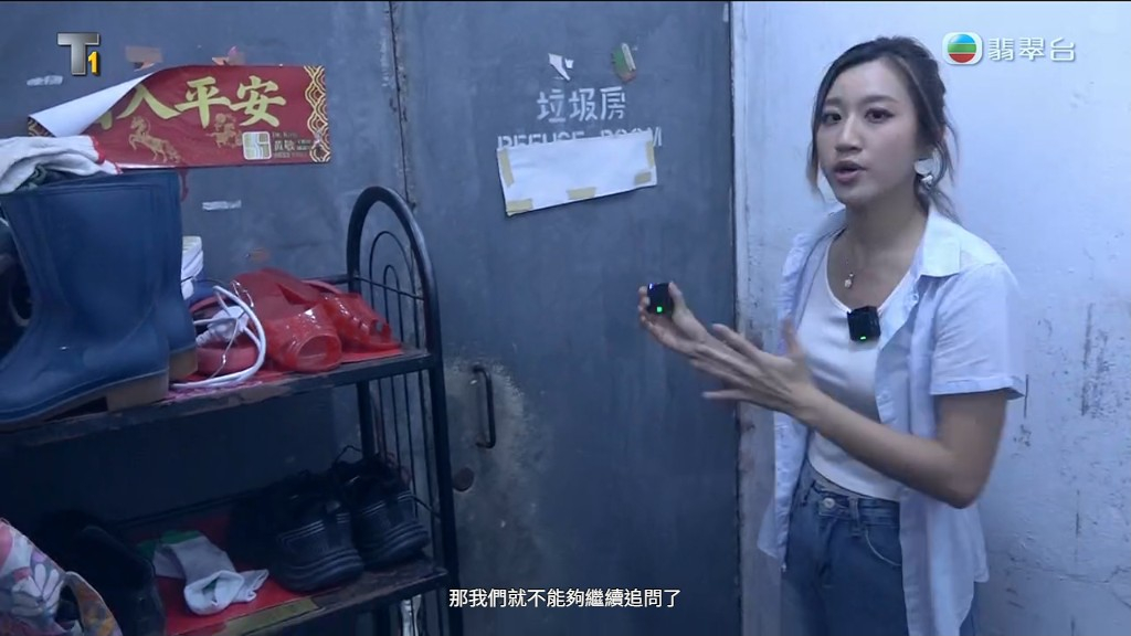 女主持在垃圾房外等待。