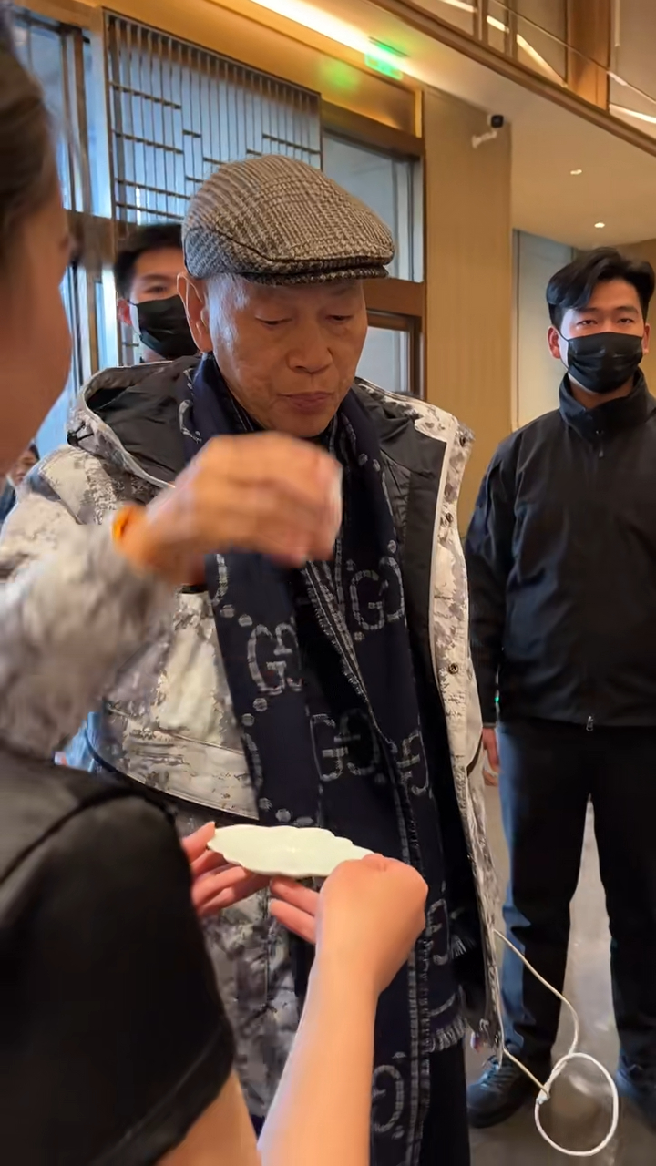 羅家英步入場地時,身旁多位工作人員為他遞上茶飲,他接過並飲用,神情專注。