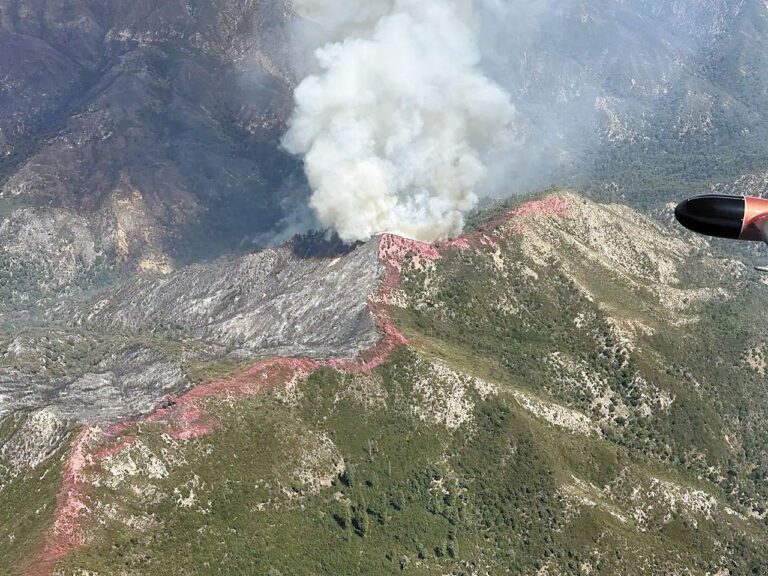 「原木山火」期間，洛斯帕德雷斯國家森林一處偏遠山脊2日仍有火勢燃燒，山頂可見飛機投下的阻燃劑。聯邦林務局圖片