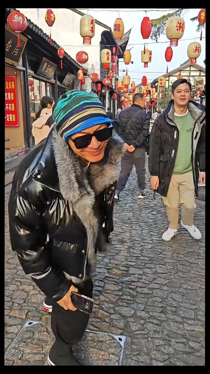 片中可見江華頭戴綠藍黃三色條紋冷帽及黑色毛毛羽絨,兒子陳耀淙則身穿綠色圓領衛衣及黑色連帽羽絨外套。