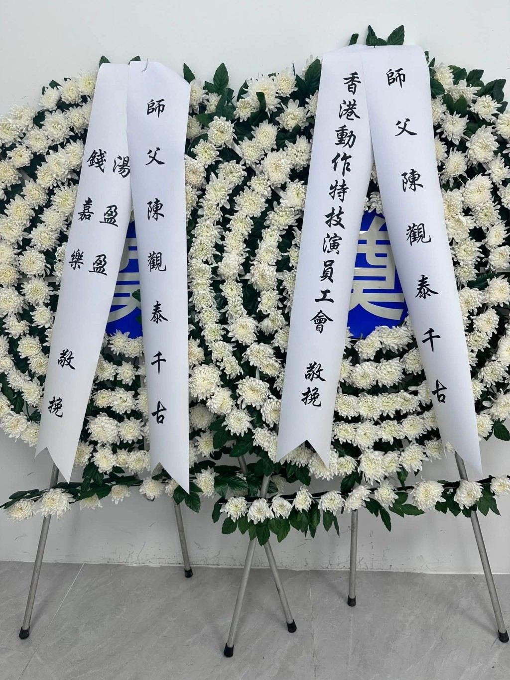 錢嘉樂以「師父」稱謂送上花牌，表達懷念與敬意。