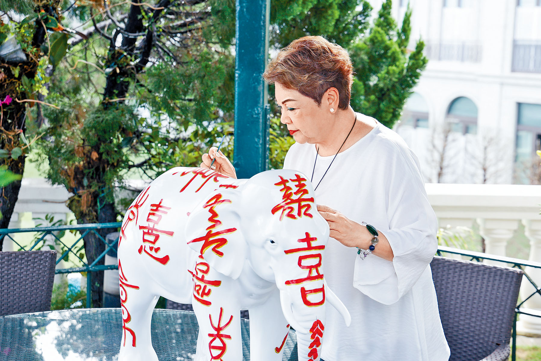 肥媽在大象身上畫上18個不同字體寫法的「喜」字。