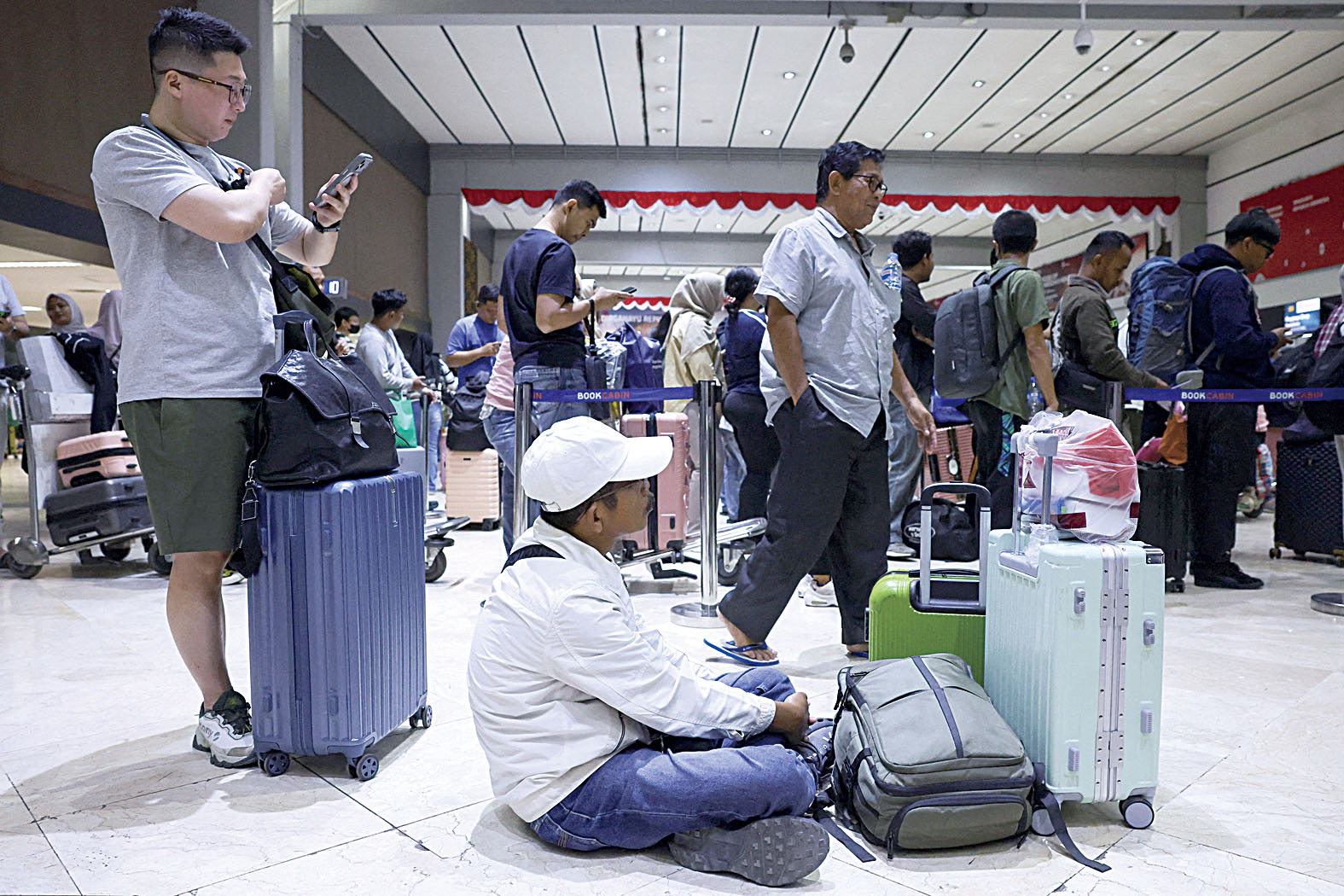 旅客被困在首都雅加蘇加諾—哈達國際機場,疲憊不堪。路透社