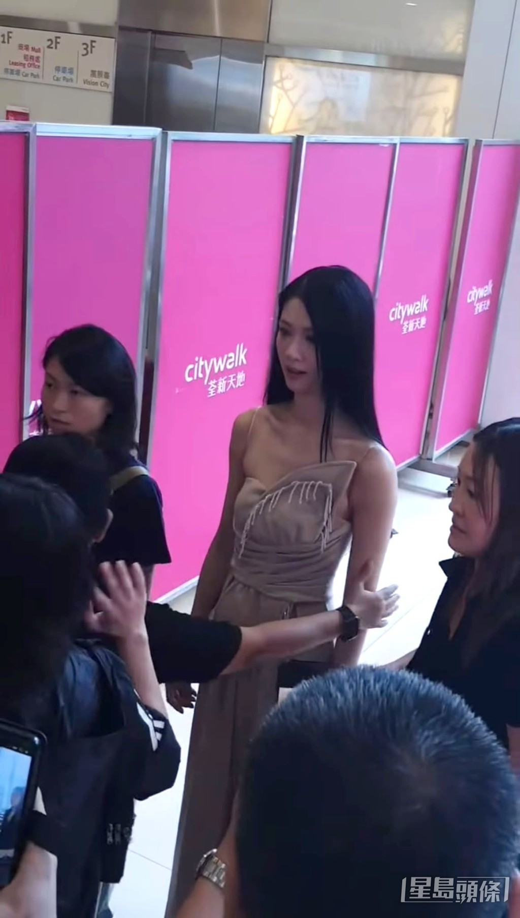 她原先在稍遠處觀察，之後走近女工作人員了解事件。