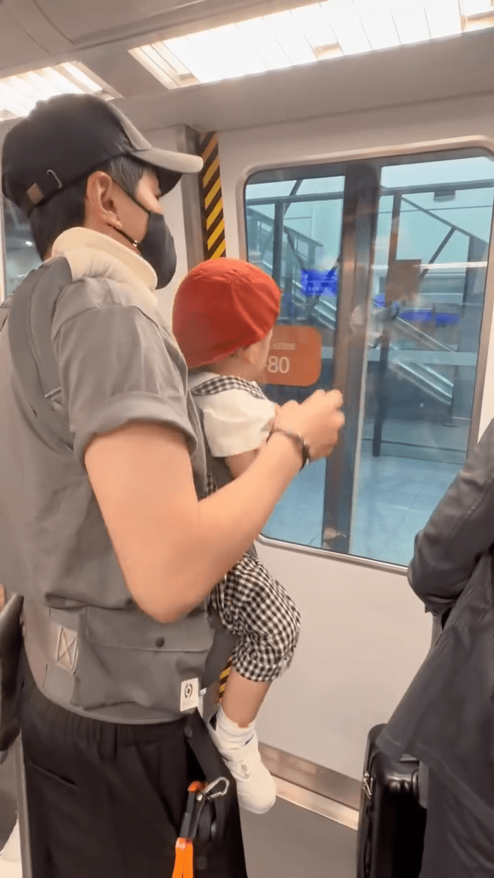 爸爸蕭正楠抱著「蕭哈哈」搭乘機場內的列車。
