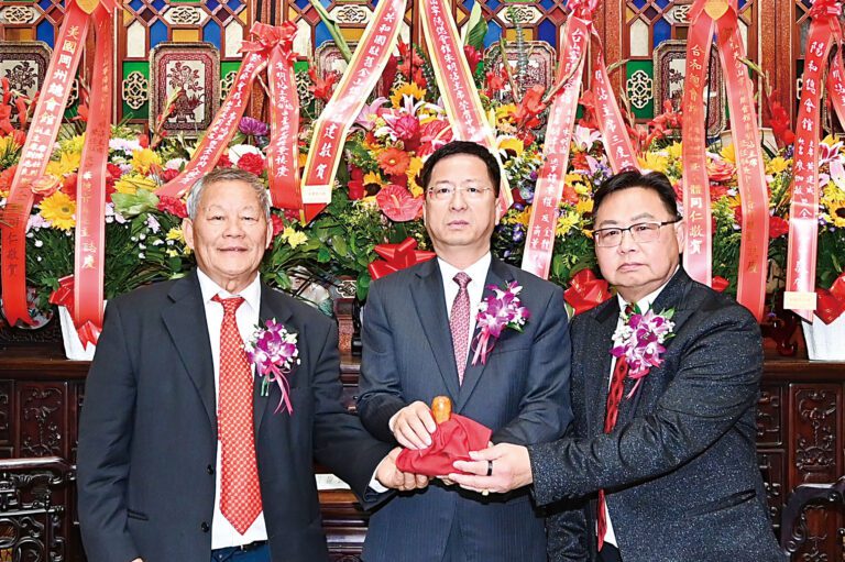 中領館總領事張建敏（中）主持監交，新任總董朱明沾（左）從滿任總董盧炳坤（右）手中接過印信，履新上任。馬紅兵攝