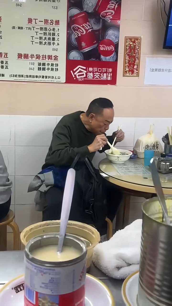他不時夾起碗中食物仔細端詳，當時身邊未有友人相伴。