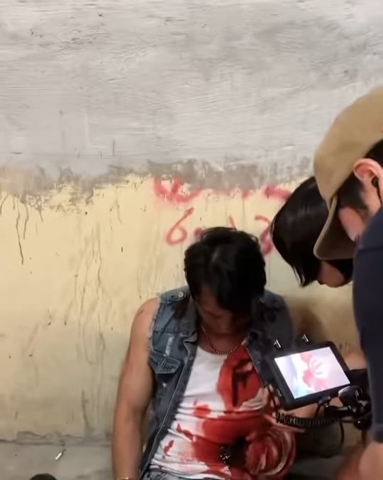 照片中的林耀聲身穿牛仔外套及白色背心,心口及腹部有大片血跡,口吐鮮血,虛弱地坐在地上。