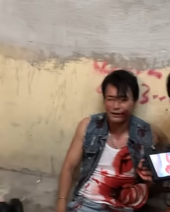 照片中可以看到林耀聲身穿一件牛仔外套及白色背心,他心口及腹部位置都有大片血跡,並且口吐鮮血,十分虛弱地坐在地上。