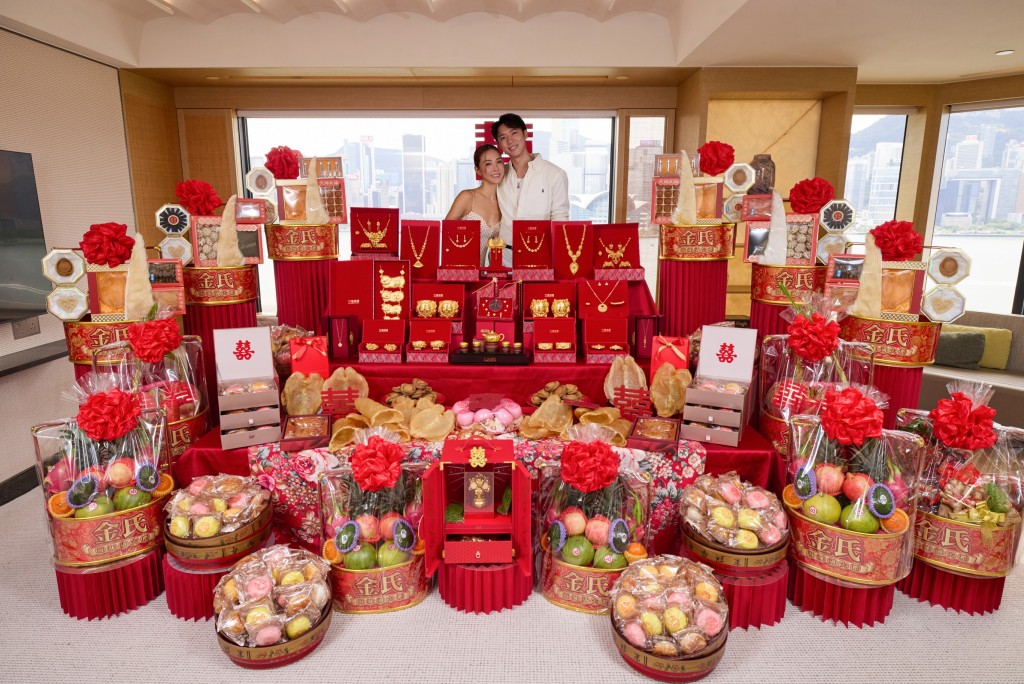 客廳長枱與梳化上擺滿各式奢華聘禮,包括鮑參翅肚、花膠、巨型生果籃及喜餅。