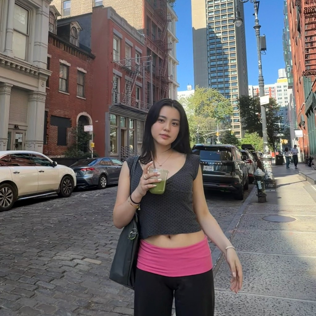 姚焯菲手持飲品拍攝街頭照,充滿留學生的隨性感覺。