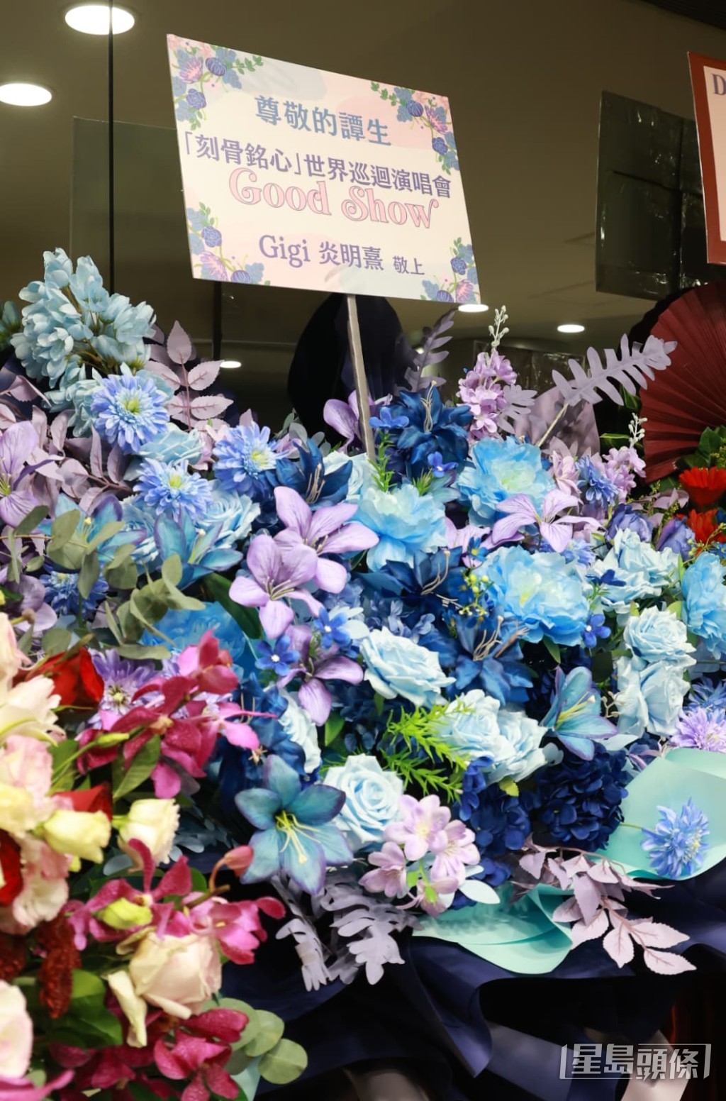 後輩歌手Gigi炎明熹送上藍色花籃,祝前輩譚詠麟Good Show。
