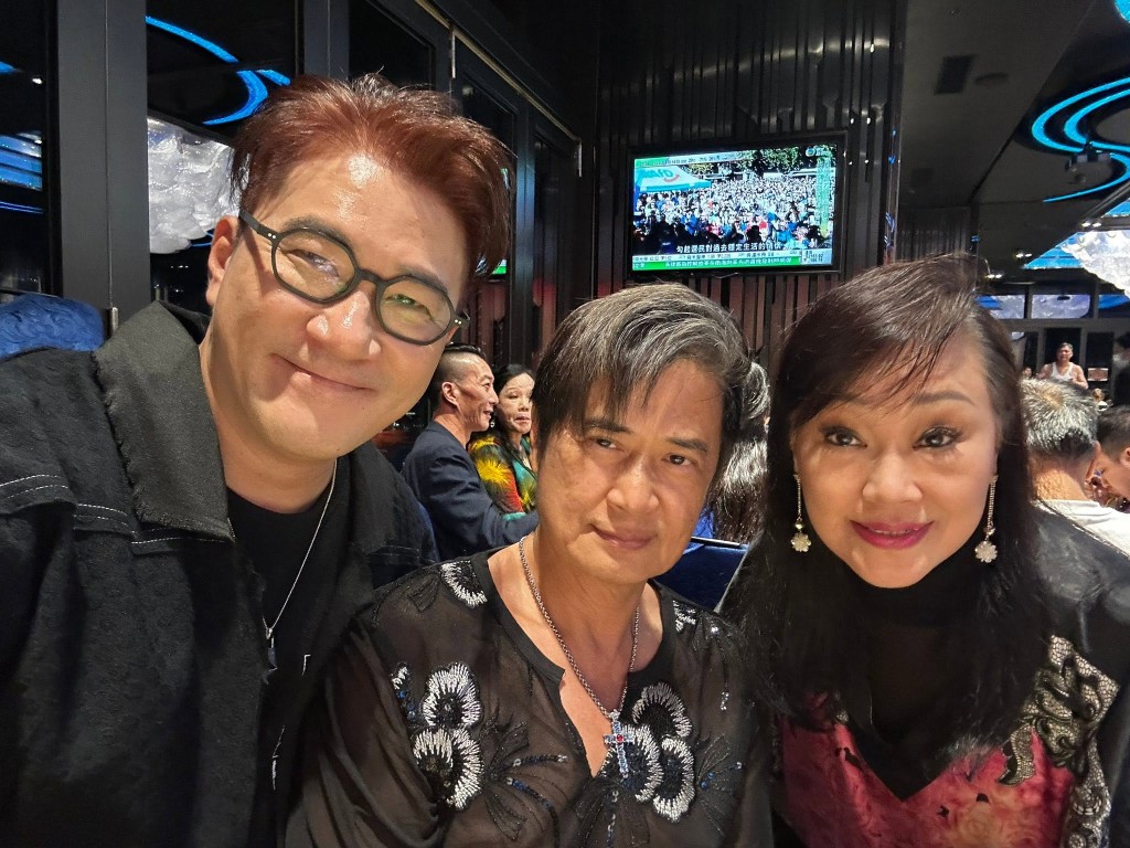王維德(中)在宴會上與友人合照。