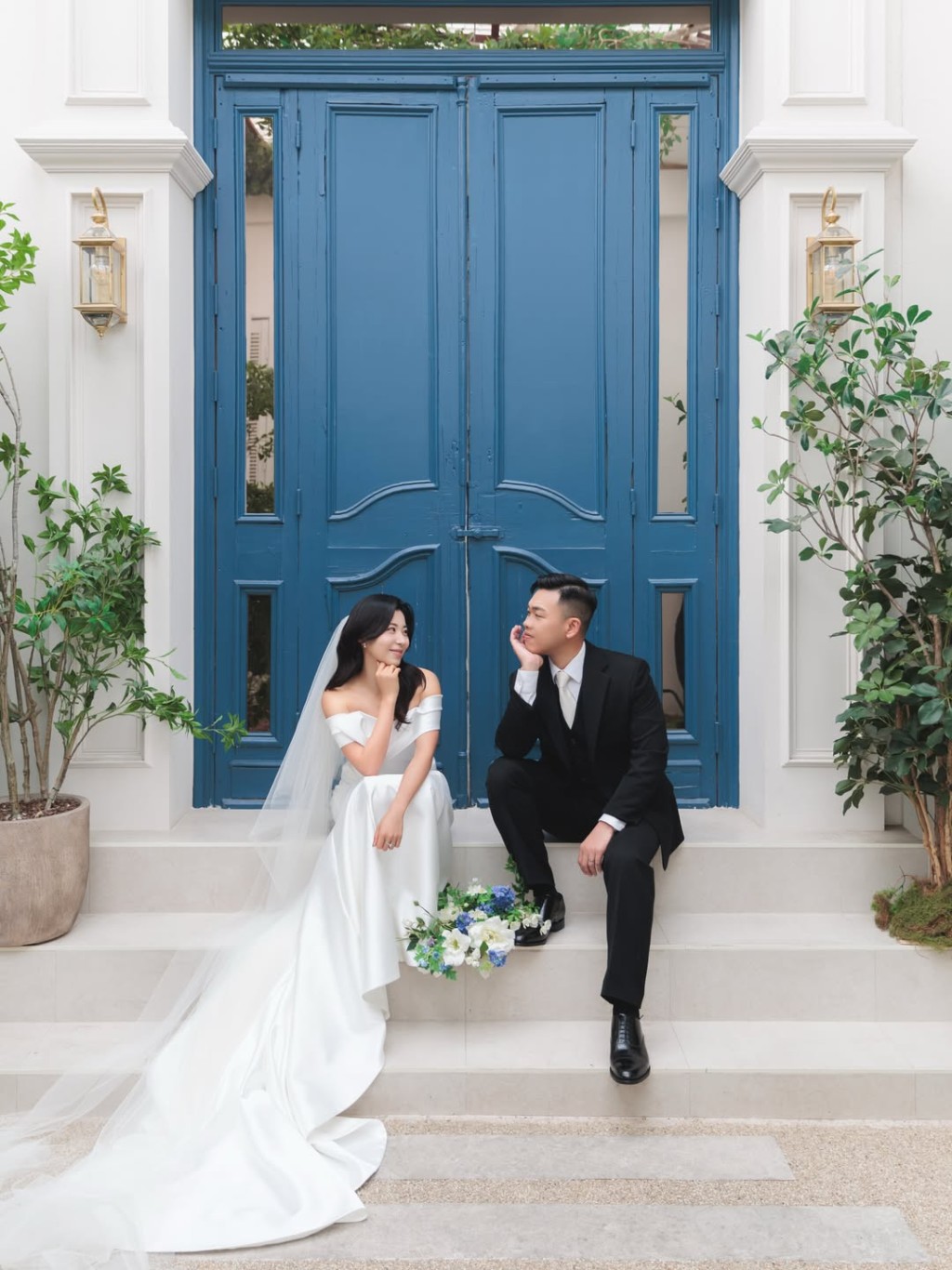 袁沅玉與未婚夫在藍色大門前甜蜜拍照。