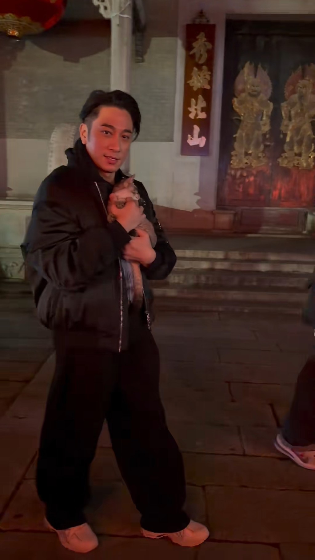 當時吳卓羲用單手緊緊地抱著貓咪。