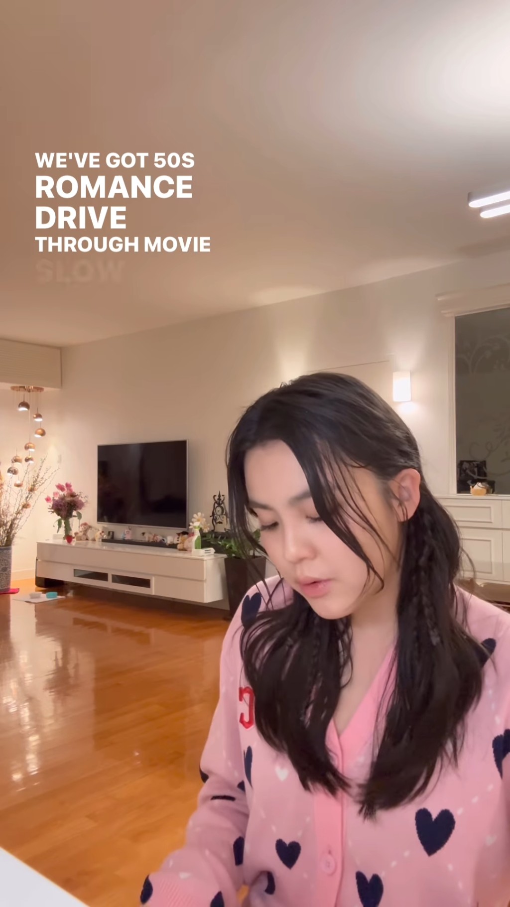 姚焯菲化上妝容,披著公主髮型,在家中以粉紅色毛衣自彈自唱。