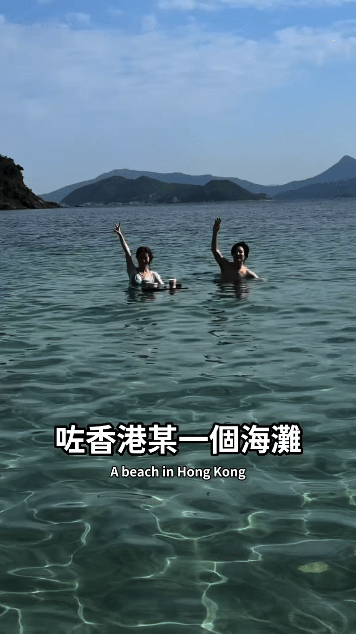 二人在香港一處海灘暢泳，享受陽光與海水。