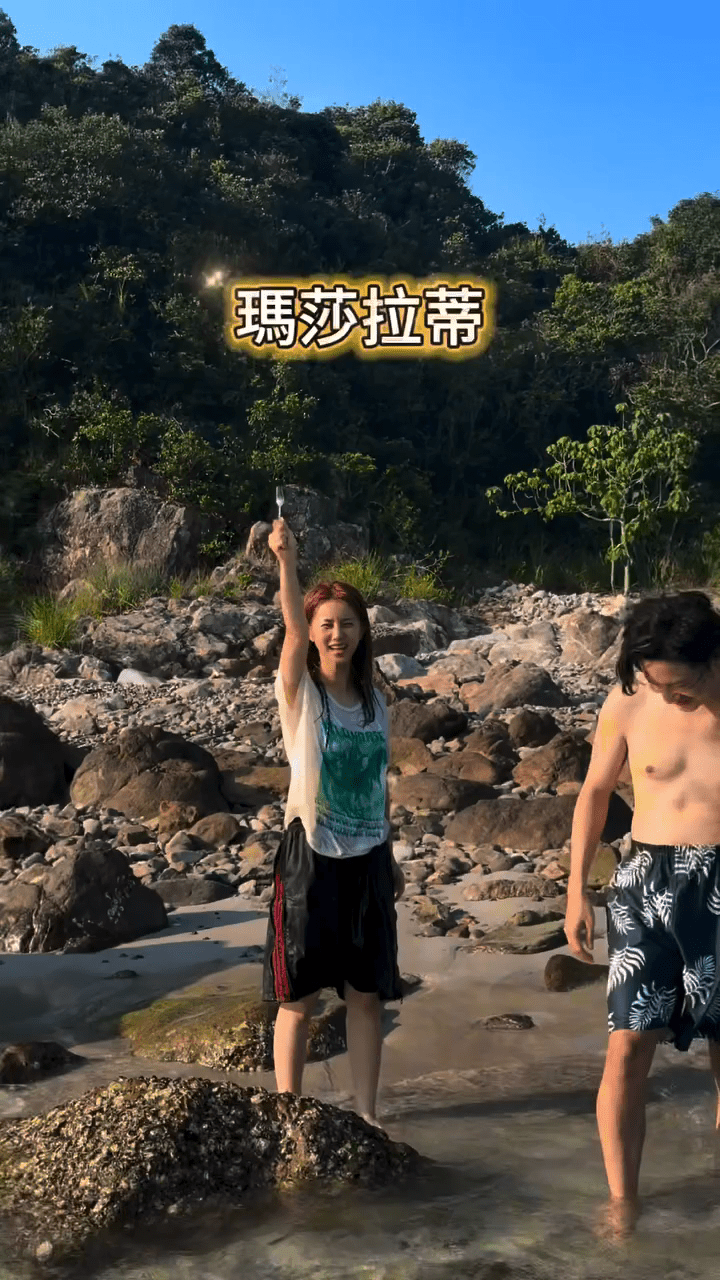 鄧月平興奮地舉起叉子，為找到野生蠔而慶祝。
