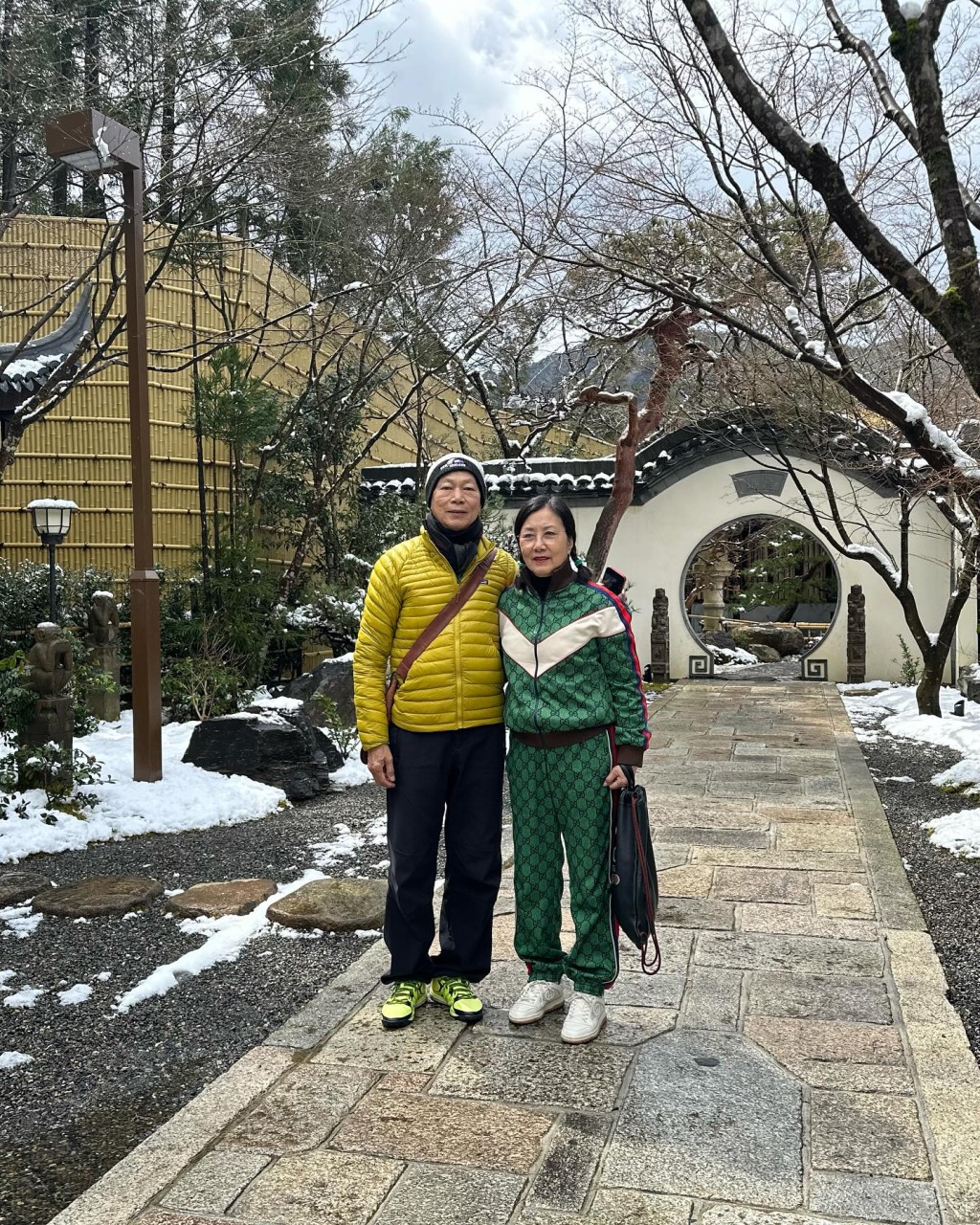 羅家英換上芥末黃羽絨，兩人到雪地中一處疑似四合院的後院打卡。