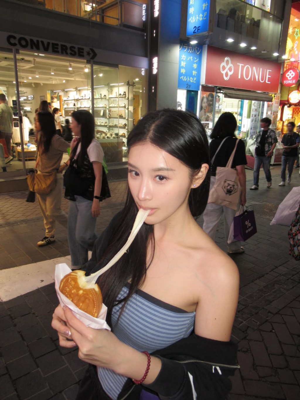 郭珮文在街頭品嚐芝士餅，畫面相當賞心悅目。