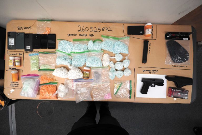 警方展示檢獲的大批疑似假冒處方藥、槍械、彈藥及手機等證物。SFPD