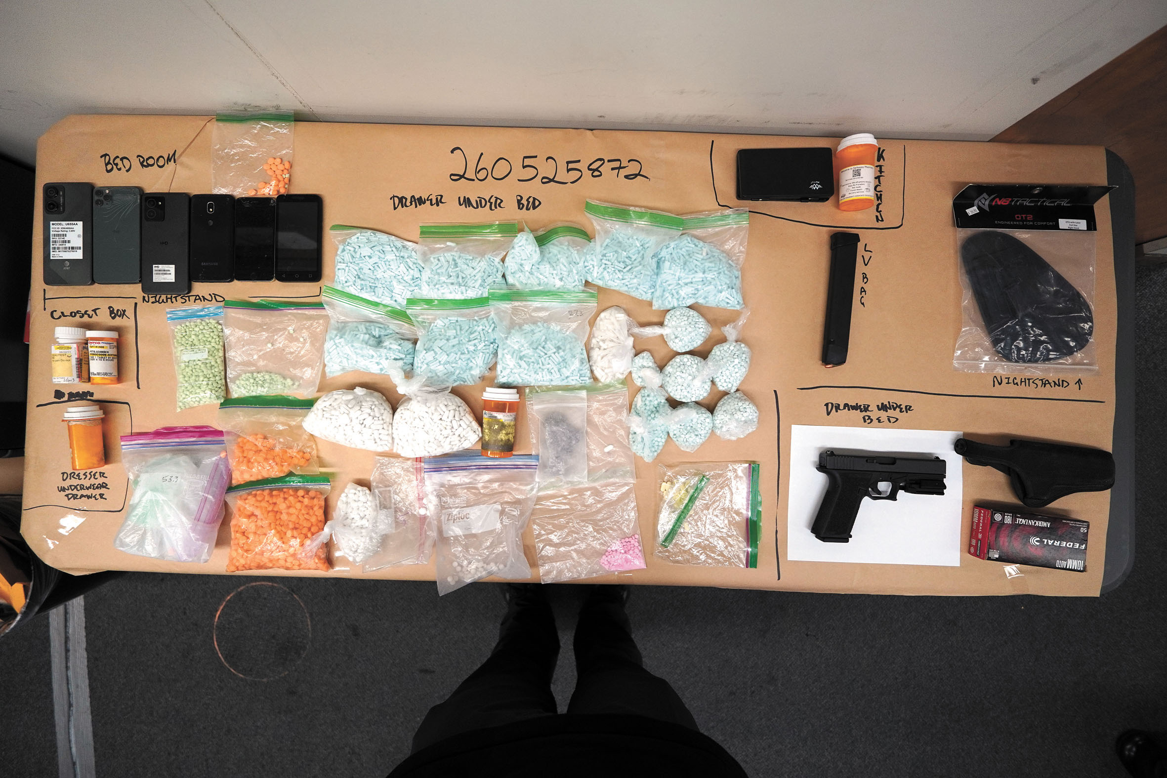 警方展示檢獲的大批疑似假冒處方藥、槍械、彈藥及手機等證物。SFPD