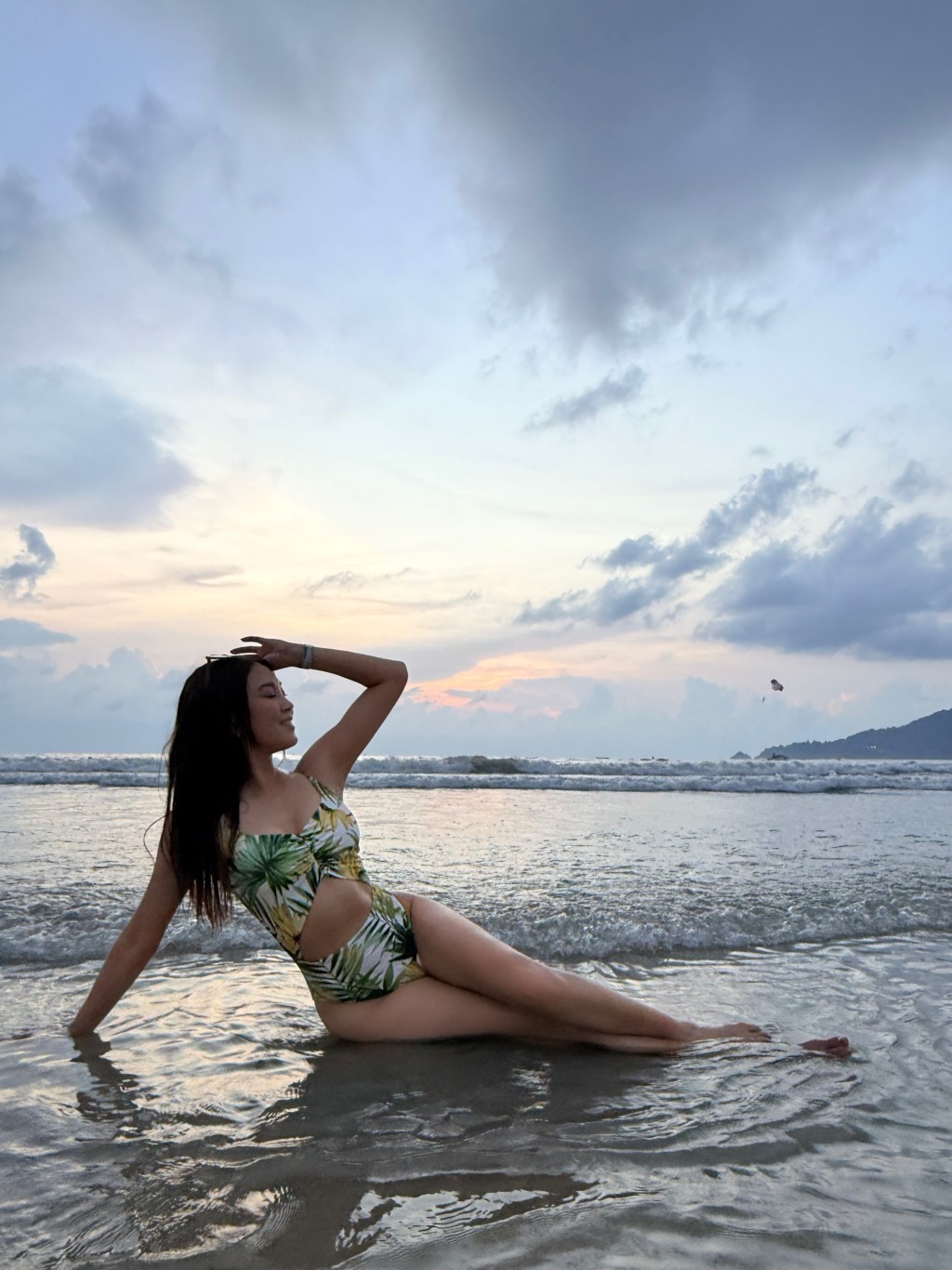 她迎著夕陽逆光露出燦爛笑容,散發健康美感。