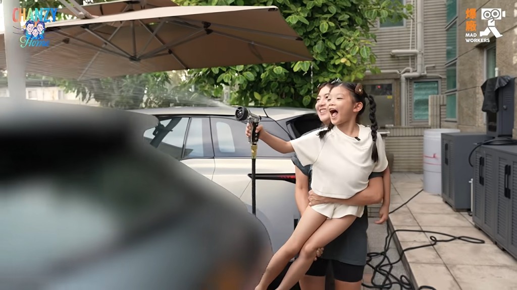 小豬比被媽媽抱起，興奮地向車身灑水。