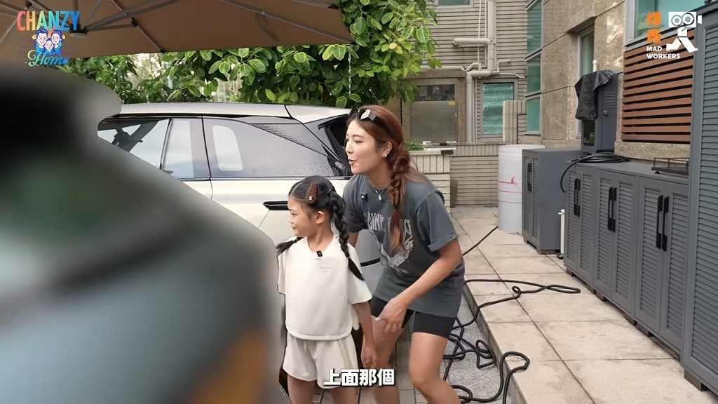單文柔指導女兒從車頂開始噴水。