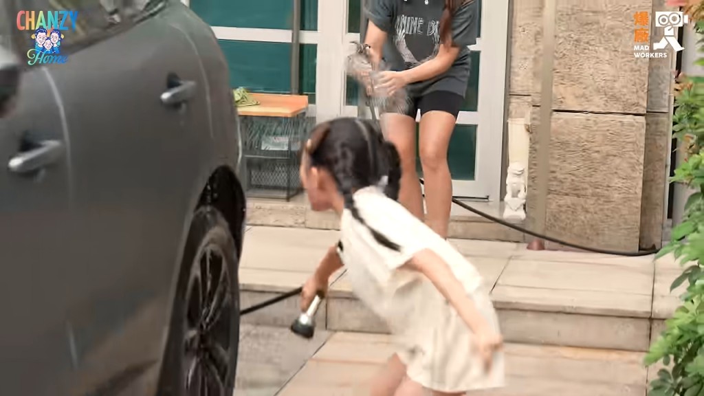 小豬比專注地用水喉沖洗車輪。