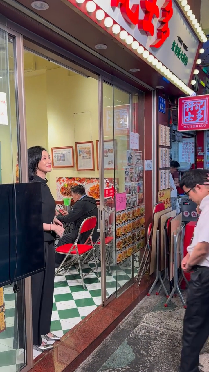 關秀媚在廣州街頭店鋪外準備拍攝，可見其身形依然纖瘦。