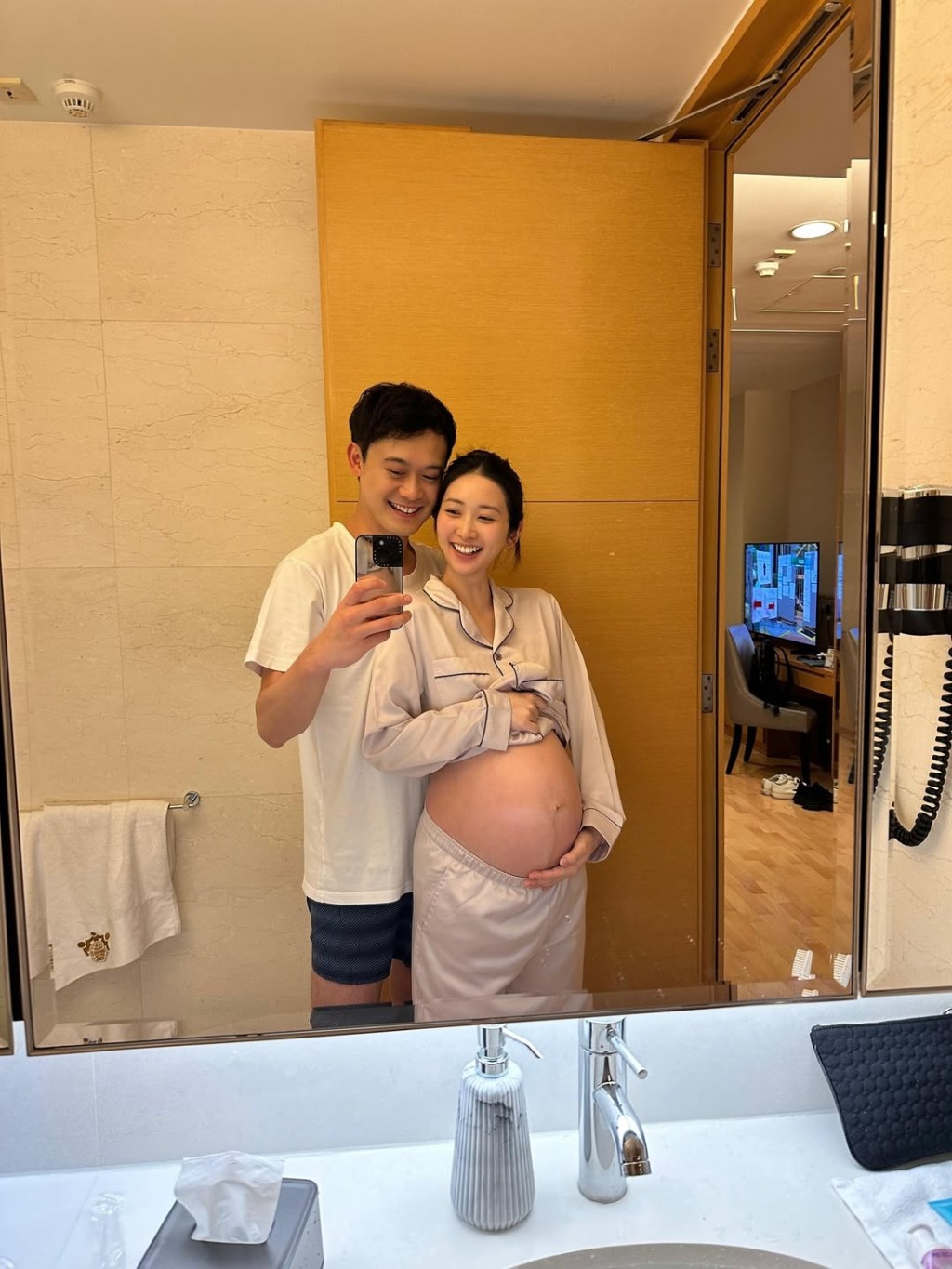 黃靜藍在醫院中,挺著孕肚與丈夫合照。
