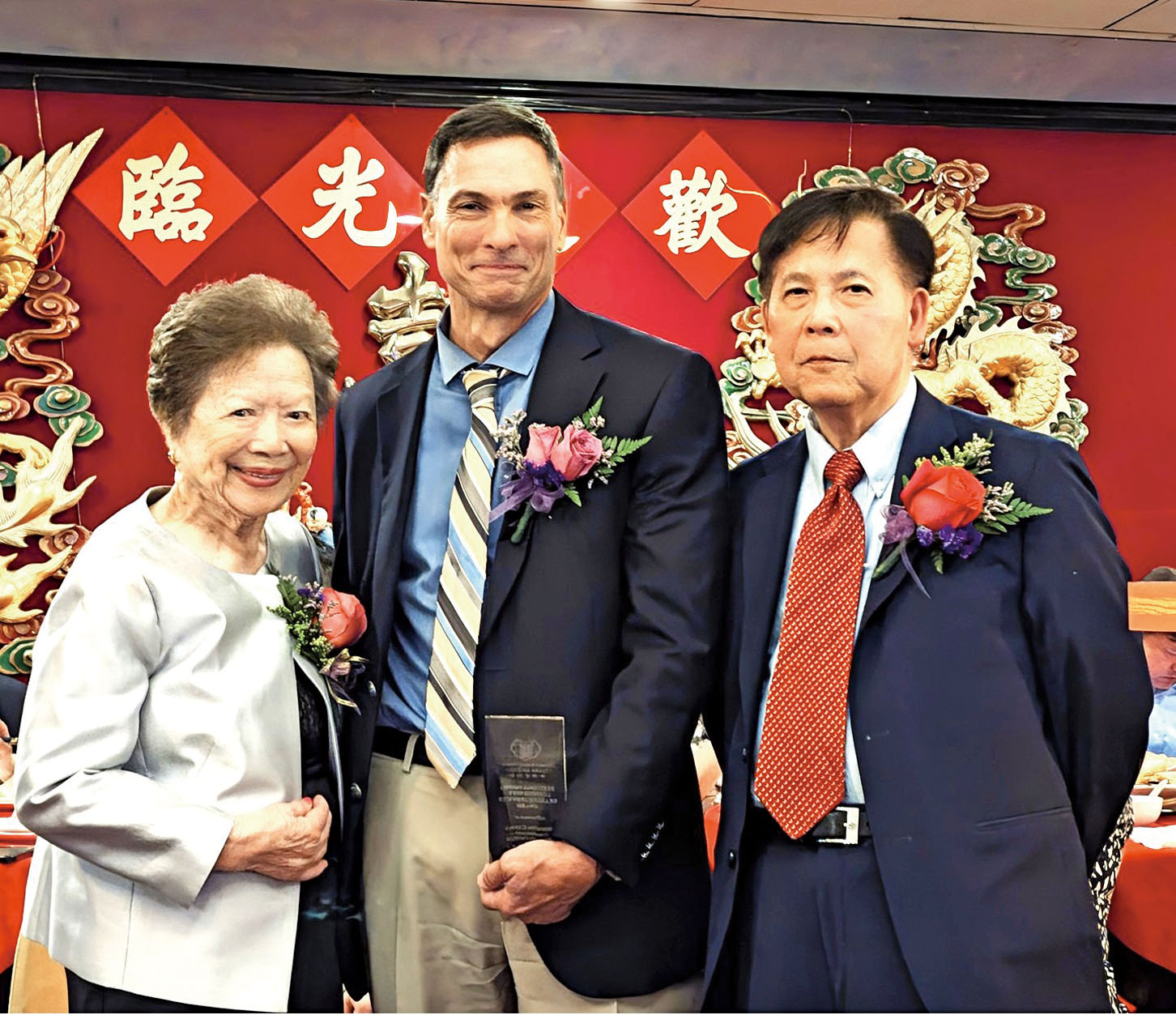梅伍銀寬（左）、陳建立（右）給華人醫務中心總裁提貝里（Eric Tiberi）頒獎。